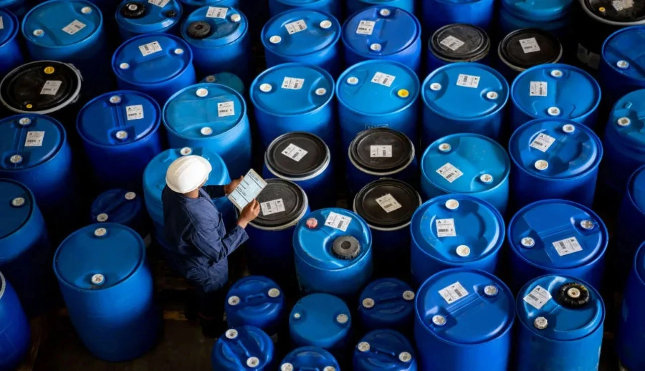 Technician checking biopharma fluid barrels